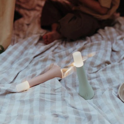 Difusores de aroma em forma de cone em manta xadrez clara, ao fundo tapete e pessoa sentada