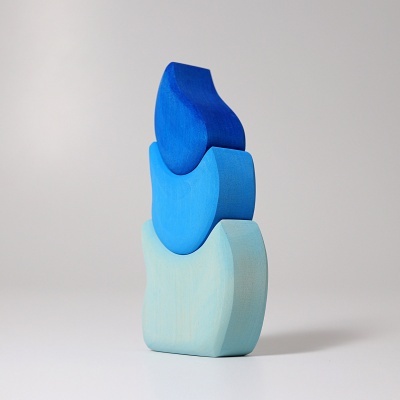 Três blocos de madeira azuis empilhados com formas curvas