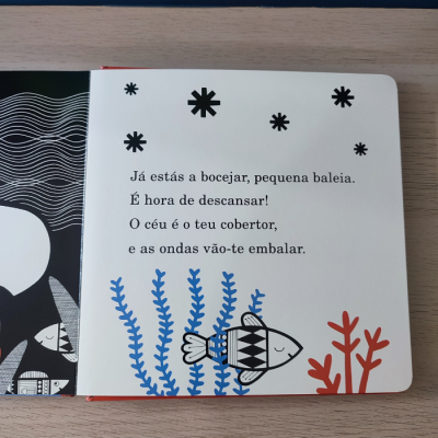 Página ilustrada de livro infantil com peixes, algas, coral e texto em português