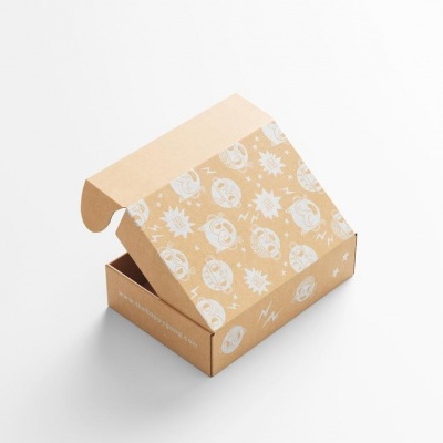 Caixa de cartão castanho claro aberta com padrão branco de desenhos de sol, lua e estrelas