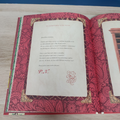Página de livro com texto em português e moldura vermelha decorativa