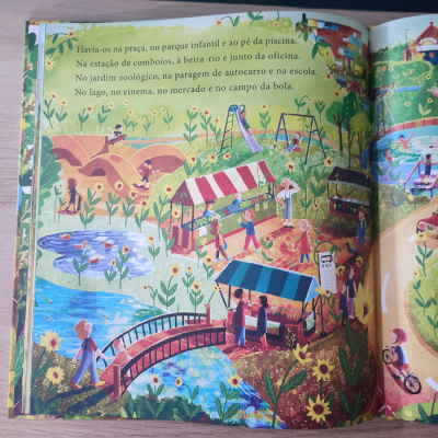 Ilustração colorida de parque infantil e mercado num livro infantil com texto em português.
