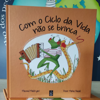 Capa de livro infantil 'Com o Ciclo da Vida não se brinca' com rã a tocar acordeão e cobra desenhadas