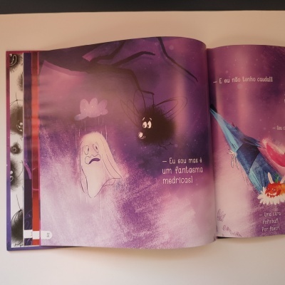 Página ilustrada de livro infantil com fantasma e morcego e texto em português