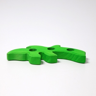 Peça de madeira verde com quatro furos circulares.