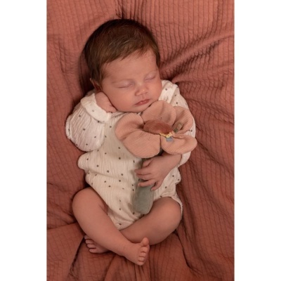 Bebé a dormir com body branco e boneco de peluche rosa