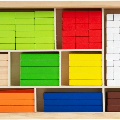 Conjunto de blocos retangulares de madeira colorida organizados em caixa de madeira.