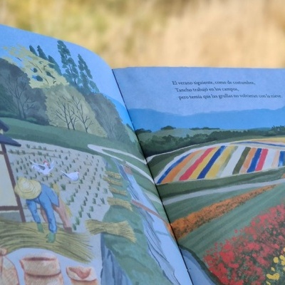 Página aberta de livro ilustrado com cena de trabalho no campo e campos floridos coloridos