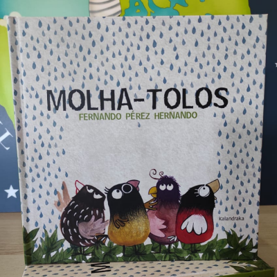 Capa do livro 'Molha-Tolos' com ilustrações de pássaros coloridos e gotas azuis no fundo