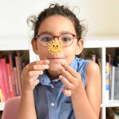Criança com óculos e autocolante de sol sorridente