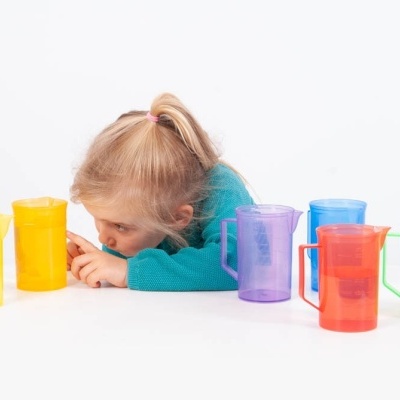 Copos plásticos coloridos em fila com criança ao fundo