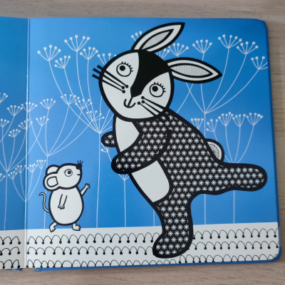 Ilustração de coelho e rato em livro infantil sobre mesa de madeira