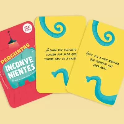 Cartas de jogo amarelas e embalagem vermelha com texto 'PERGUNTAS INCONVENIENTES'