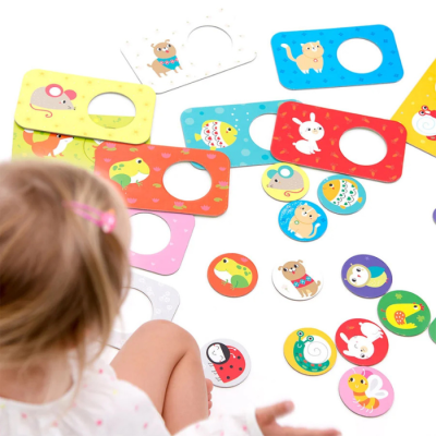 Cartões e peças redondas com animais coloridos para encaixe, com criança a brincar