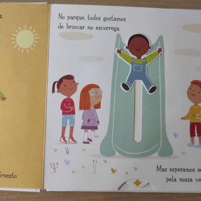 Página de livro ilustrado com crianças junto a um escorrega verde e texto em português