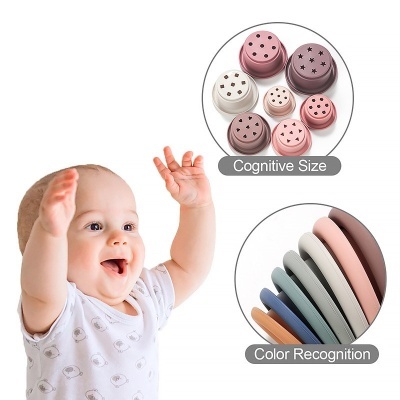 Bebé a brincar com brinquedos educativos coloridos em fundo branco