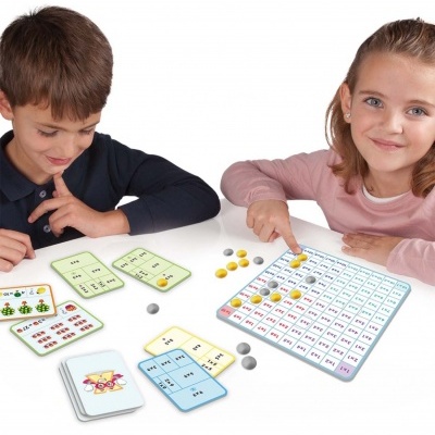 Crianças a jogar jogo educativo com tabuleiro numérico e cartas coloridas
