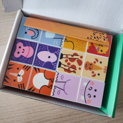 Blocos de madeira coloridos com desenhos de animais numa caixa aberta