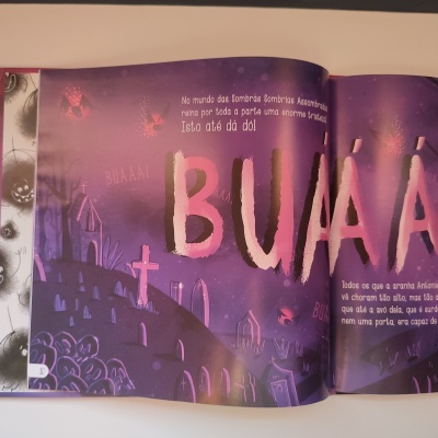 Página de livro infantil com ilustração de cemitério e texto com palavra BUÁÁÁ em destaque