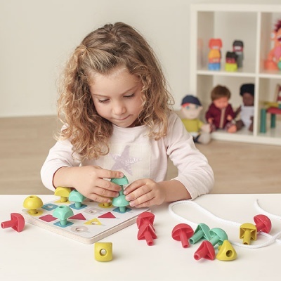 Criança a brincar com brinquedo de madeira colorido com formas geométricas