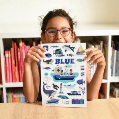 Adolescente segura poster branco com imagens marinhas coloridas e a palavra BLUE