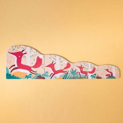 Puzzle de madeira com quatro peças desenhadas com raposas cor-de-rosa em fundo amarelo