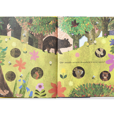 Livro infantil aberto com ilustrações de animais da floresta e texto em castelhano.