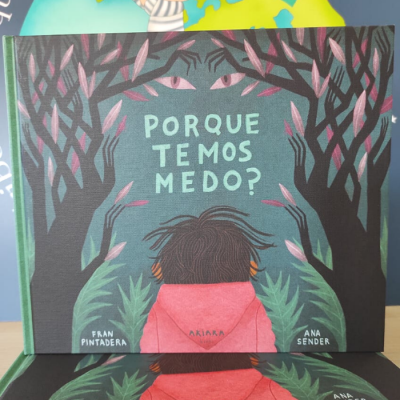 Capa de livro infantil com título 'PORQUE TEMOS MEDO?' e ilustração de criança e árvores com olhos.