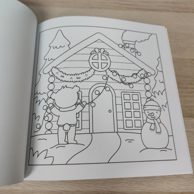 Livro de colorir aberto com desenho de casa de Natal e boneco de neve