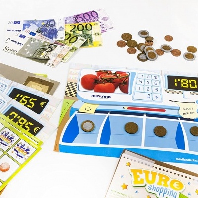 Dinheiro e caixa registadora de brinquedo com cartão de jogo e texto EURO shopping