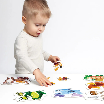 Criança a montar puzzles de madeira de animais