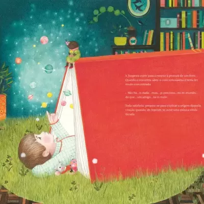 Criança deitada na relva a ler um grande livro vermelho, com estante e planta ao fundo.