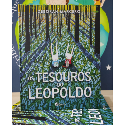 Livro 'Os Tesouros do Leopoldo' com ilustração de coelhos num campo de plantas