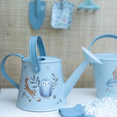 Regador azul claro com desenhos de animais e plantas num ambiente de jardinagem