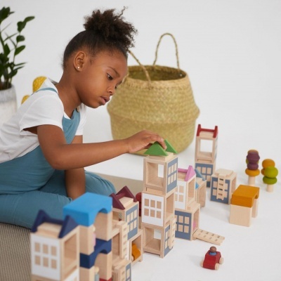 Criança a brincar com blocos de construção de madeira coloridos