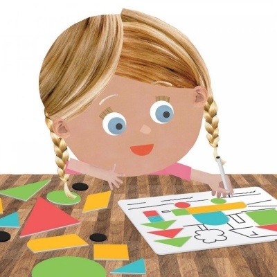 Criança animada a desenhar formas coloridas num papel sobre uma mesa de madeira