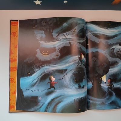 Páginas de livro infantil com ilustração de crianças numa floresta à noite e texto em português.