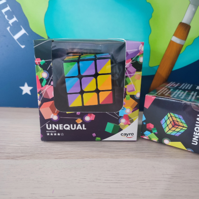 Quebra-cabeças tipo cubo UNEQUAL colorido na embalagem preta com padrões coloridos