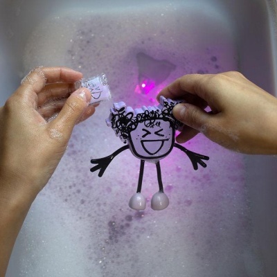 Figura de desenho animado a ser lavada com espuma e bolhas na água de um lavatório.