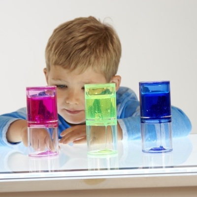 Garoto com cubos coloridos sobre superfície iluminada