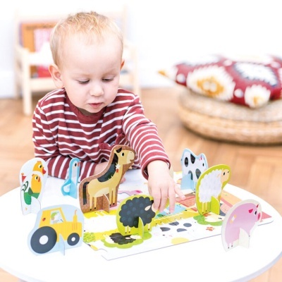 Criança a brincar com brinquedo de madeira com animais coloridos e trator amarelo