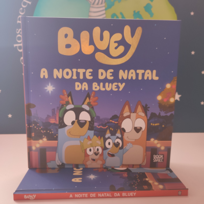 Capa de livro infantil 'BLUEY A NOITE DE NATAL DA BLUEY' com vários cães animados e fundo natalino