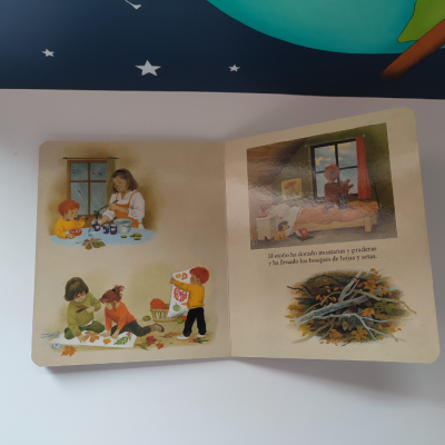 Livro infantil aberto com ilustrações de crianças e texto em espanhol sobre o outono
