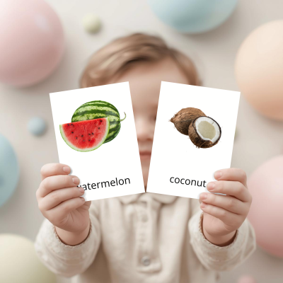 Cartas educativas com imagens de melancia e coco seguradas por uma criança.