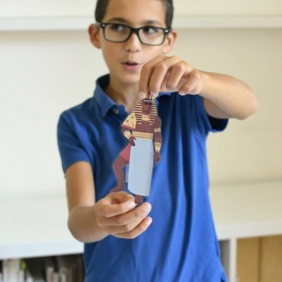 Rapaz azul segura figura recortada de papel colorida com avental