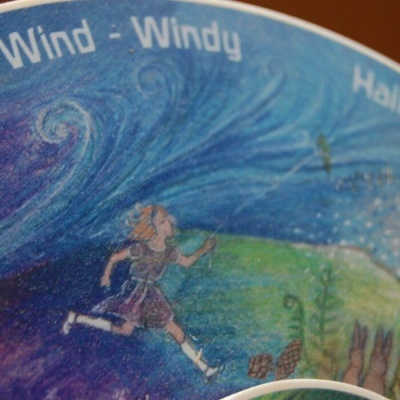 Ilustração colorida com texto Wind - Windy e menina a correr em natureza