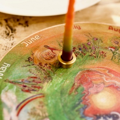 Placa decorativa com meses do ano e vela colorida central