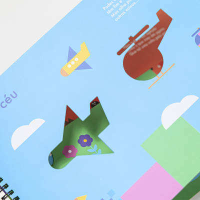 Página de livro com ilustrações de veículos voadores e texto 'No céu'