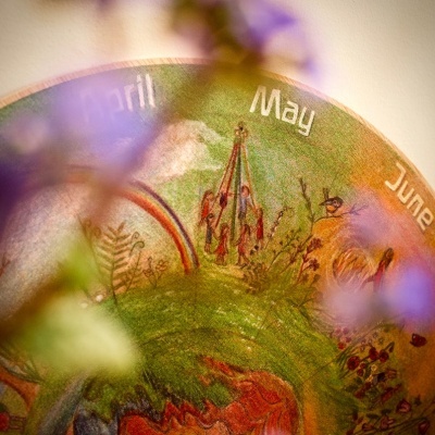 Globo terrestre decorativo com meses do ano e flores desfocadas