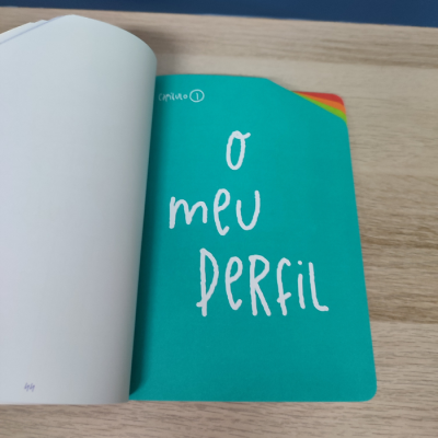 Livro aberto com página verde e texto branco 'O meu perfil'